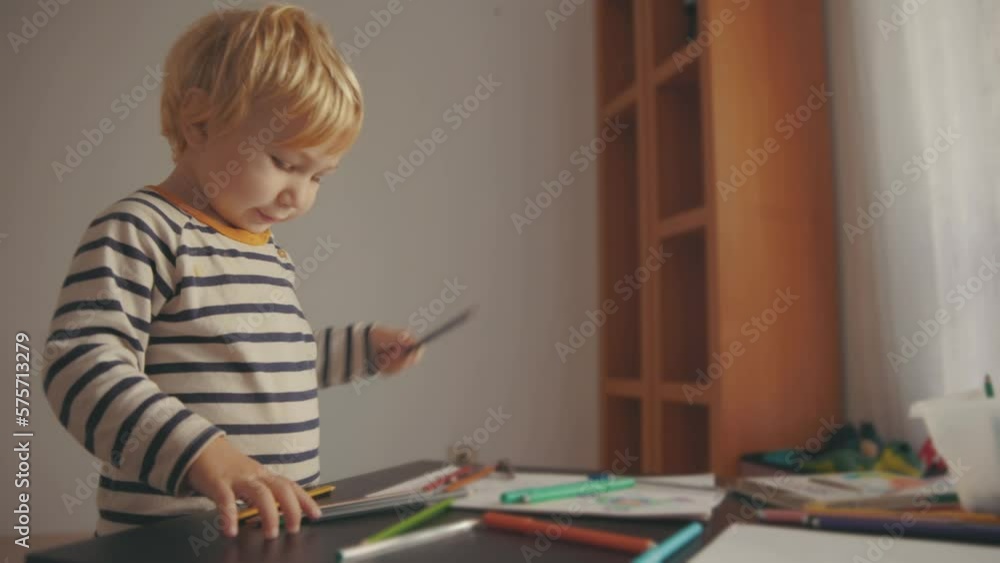 Cute little blonde boy drawing with color pencils Cute little blonde boy drawing with color pencils