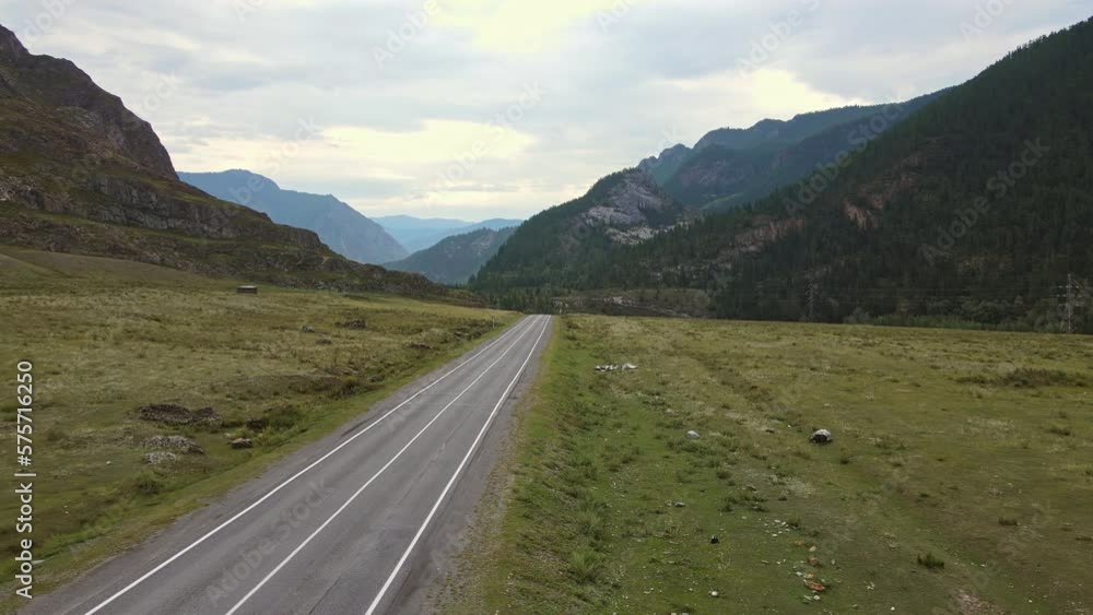 Aerial view of a valley with a winding river and road surrounded by mountains Aerial view of a valley with a winding river and road surrounded by mountains