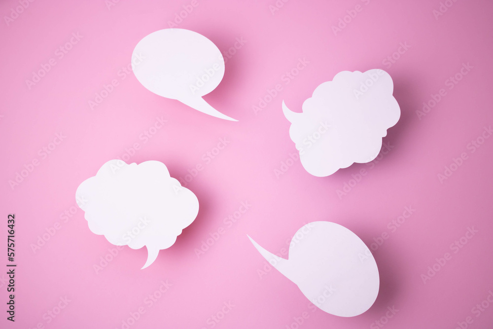 Paper templates in the form of clouds and bubbles for messages on a pink background.