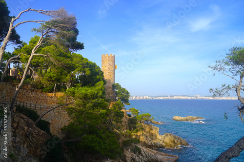 view from the Camí de Ronda hiking trail to the Torre Colomina tower and looking across the Mediterranean Sea to the coastal town of Palamos, Costa Brava, Spain photo