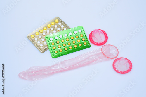 Packs of pills isolated on white background, birth control pills. pink condom ready to use. Medical concept