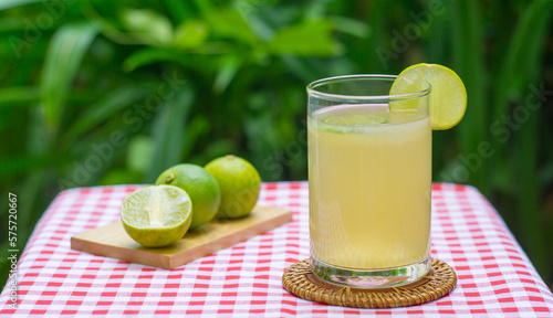 Fresh drink lime juice in the glass on panda leave background. Glass filled with fresh made lemon Juice vitamin drink.