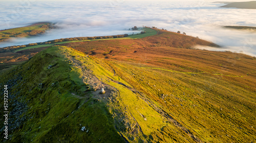 Aerial view of hillsides above a temperature inversion and sea of fog at sunset © whitcomberd