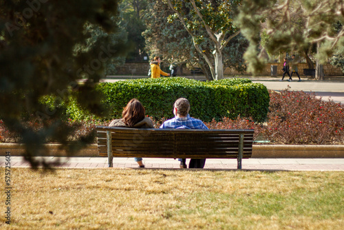 adult couple sitting on a bench in the park resting