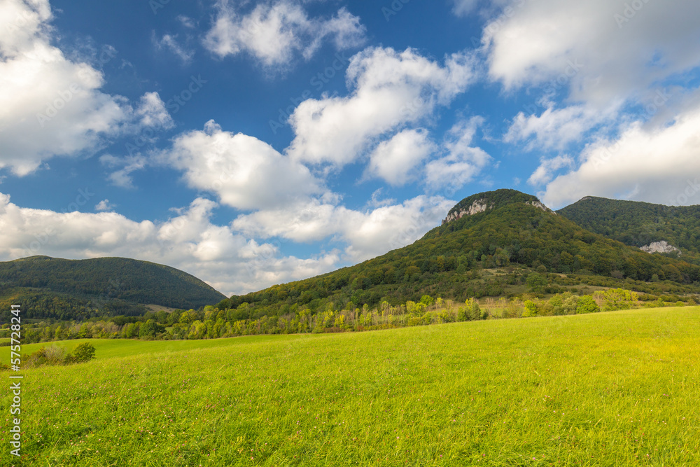 Summer rural landscape with green grass and hills at sunny day.