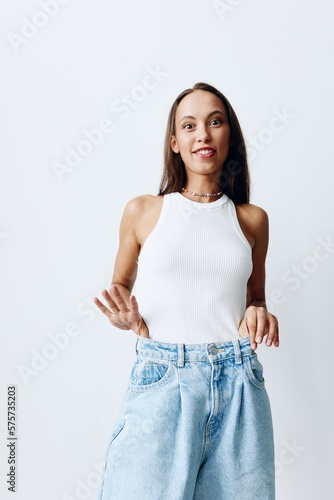 Portrait of a young beautiful woman with tanned skin fashion model on a white background in a white T-shirt and blue jeans with a beautiful smile
