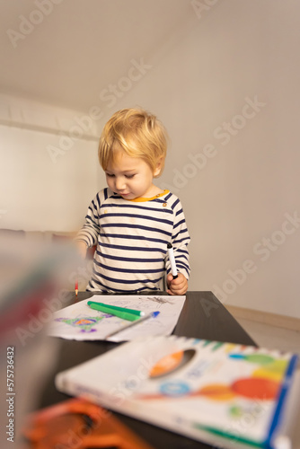 Cute little boy drawing with color pencils
