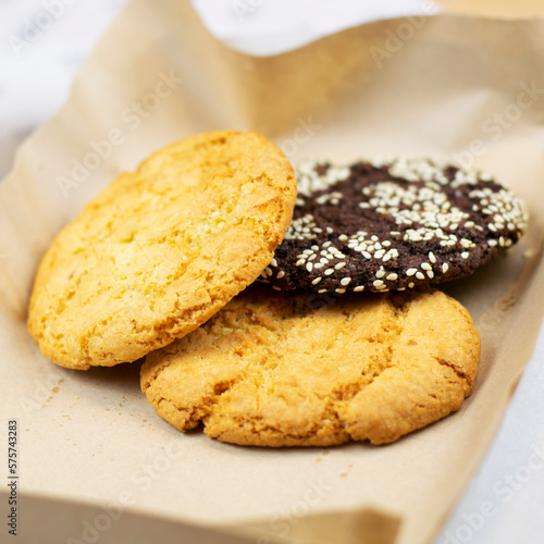 Appetizing cookies with seeds on paper close-up