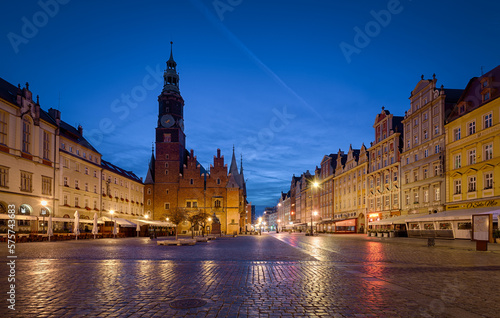 Market square in Wroclaw with buildings, tower of the old town hall and city lights during evening