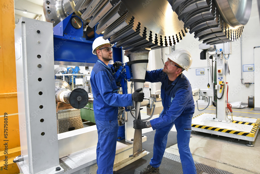workers assembling and constructing gas turbines in a modern industrial factory workers assembling and constructing gas turbines in a modern industrial factory