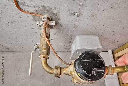 Home's main water line, meter, shutoff valve and copper grounding wire with clamp