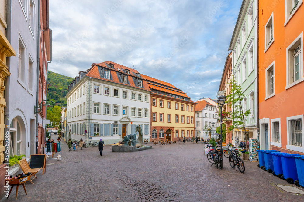 The Sumebrunnen Fountain surrounded by colorful buildings of apartments, shops and cafes at Heumarkt Square in the old town Altstadt of Heidelberg Germany.