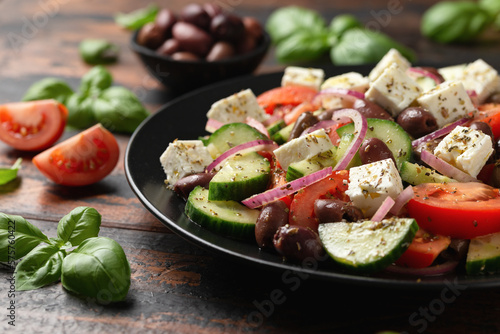 Fotografiet Greek salad with fresh vegetables, feta cheese, kalamata olives, dried oregano, red wine vinegar and olive oil