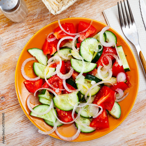Vegetarian salad with fresh cucumbers, tomatoes, onion and olive oil, nobody