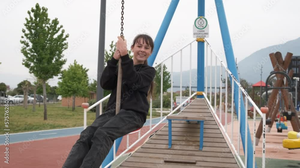 Teen adventure on rope swing. A happy teen girl have an active adventure on rope swing on the playground in summer. Teen adventure on rope swing. A happy teen girl have an active adventure on rope swing on the playground in summer.