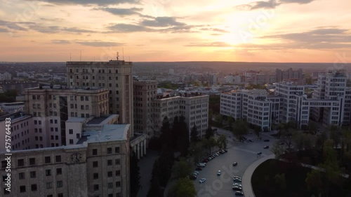 Sunset city aerial speed-up pull-out view on Karazin National University and Derzhprom buildings on Svobody Square with epic golden clouds. Kharkiv, Ukraine photo