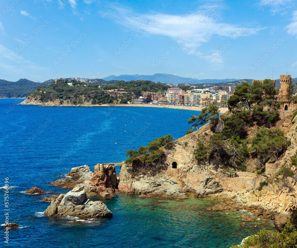 Summer sea rocky coast view with Castle of Sant Joan (Sa Caleta beach, Lloret de Mar town, Catalonia, Spain). People are unrecognizable.
