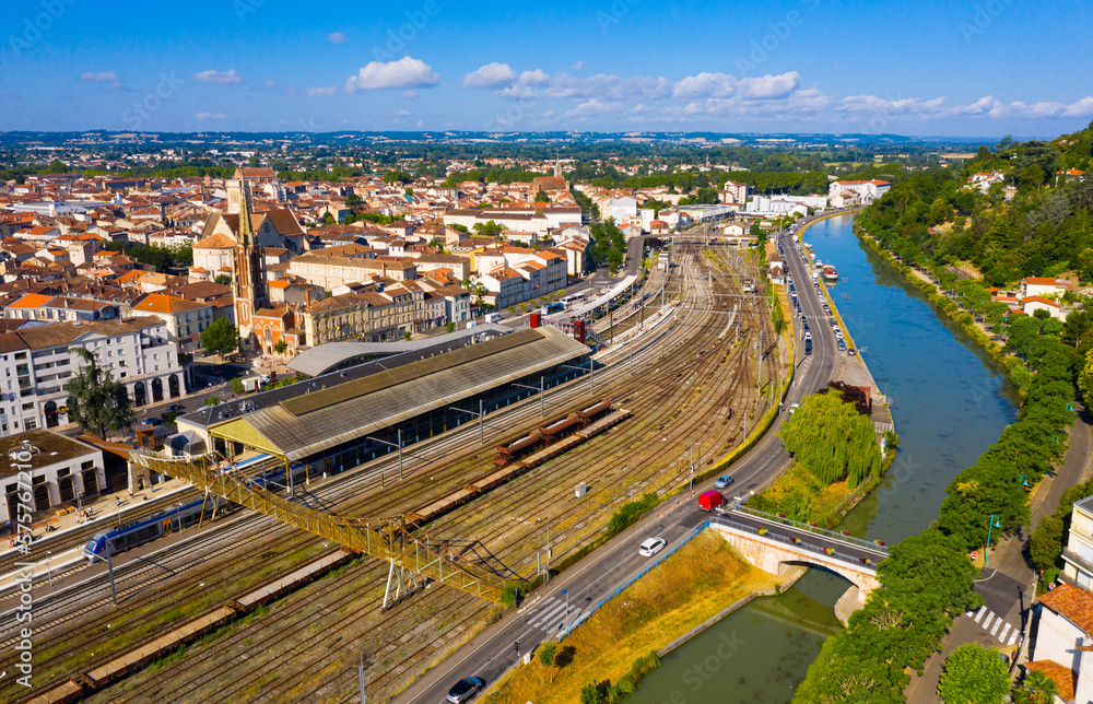 View from drone of Agen summer cityscape with embankment on canal of Garonne river and railroad tracks, France