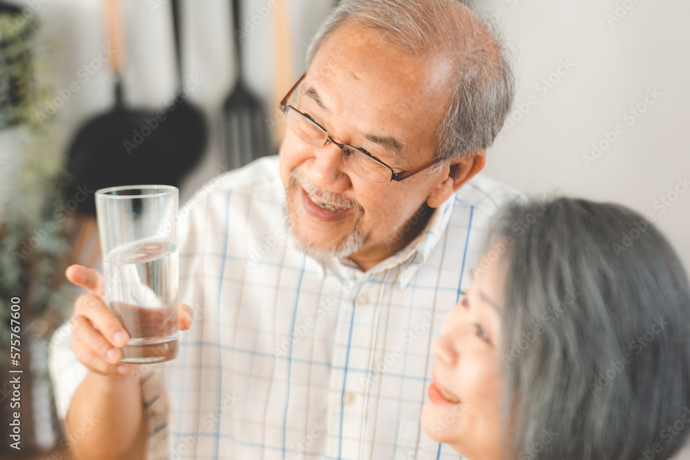 Family health care in house concept, Asian senior elderly couple drink a glass of water in kitchen room at home, Mature older thirsty grandparent holding clean mineral natural in glass, peace of mind Family health care in house concept, Asian senior elderly couple drink a glass of water in kitchen room at home, Mature older thirsty grandparent holding clean mineral natural in glass, peace of mind