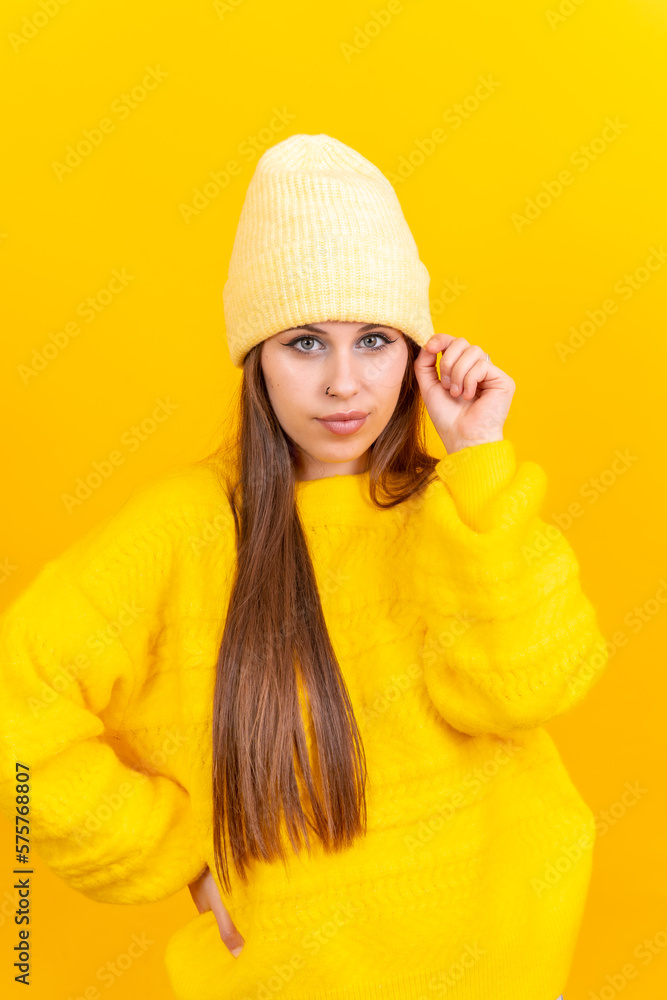 Close up portrait of a young caucasian woman in wool sweater isolated on yellow background, smiling Close up portrait of a young caucasian woman in wool sweater isolated on yellow background, smiling
