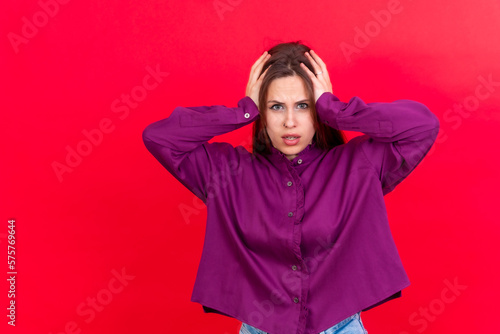 Photo portrait of a scared young woman isolated on a red background © unai