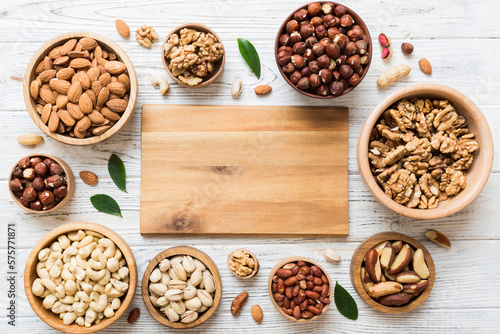 mixed nuts in wooden bowl. Mix of various nuts on colored background. pistachios, cashews, walnuts, hazelnuts, peanuts and brazil nuts