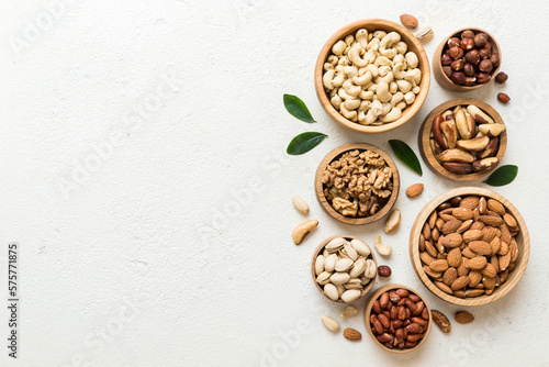 mixed nuts in wooden bowl. Mix of various nuts on colored background. pistachios, cashews, walnuts, hazelnuts, peanuts and brazil nuts