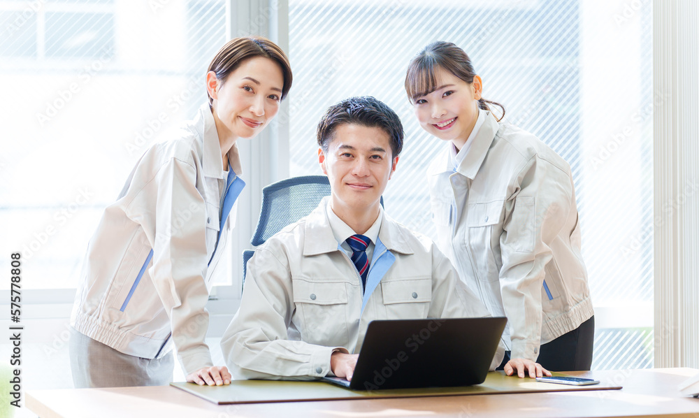 オフィスでパソコンを使う作業服を着た人々 オフィスでパソコンを使う作業服を着た人々