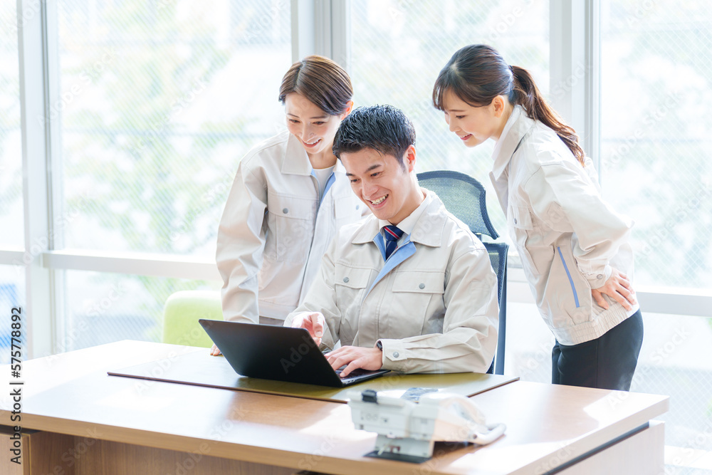 Obraz premium オフィスでパソコンを使う作業服を着た人々