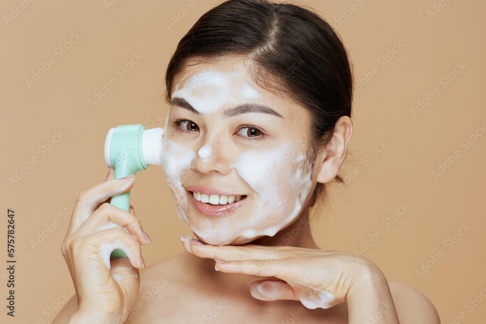 Portrait of young asian woman with massager washing face Portrait of young asian woman with massager washing face