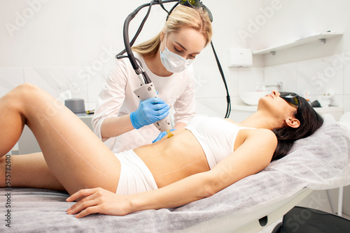 alexandrite laser hair removal procedure in cosmetology clinic, cosmetologist doctor in uniform makes depilation