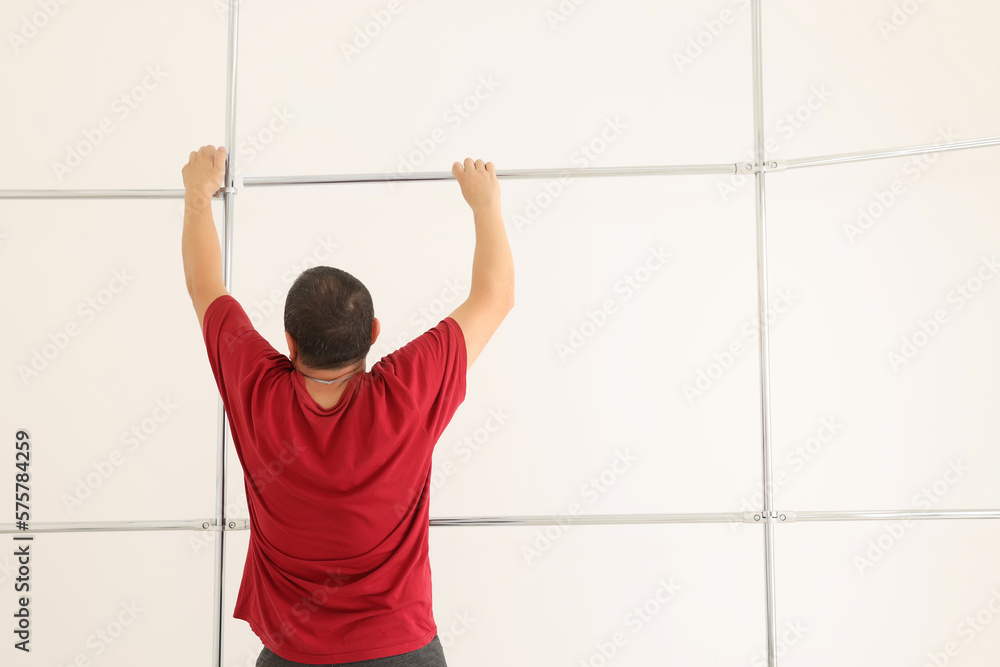 Naklejka premium Worker installing new metal pipes indoors, back view