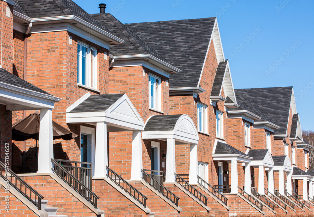 Row of red brick luxury townhouses in residential district. Row of red brick luxury townhouses in residential district.