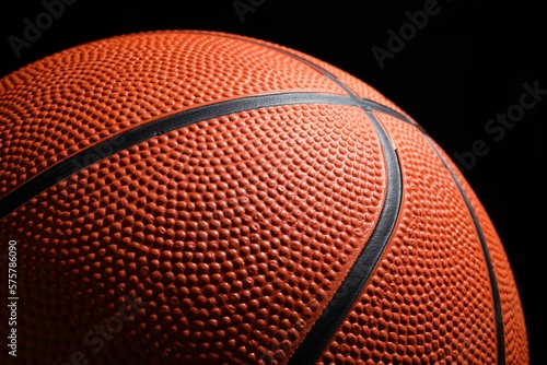 Orange basketball ball on black background, closeup