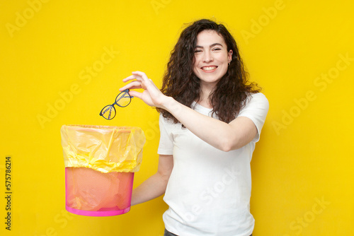 young cheerful girl throws glasses into trash can, the concept of treatment and vision correction