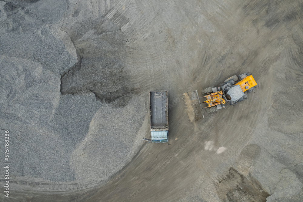 Sand loaders are shoveling rocks into dump trucks. Sand loaders are shoveling rocks into dump trucks.