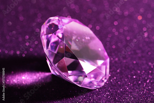Beautiful diamond on shiny purple background  closeup