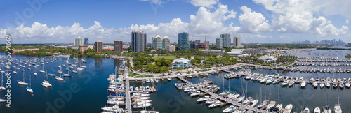 Miami Florida coastal landscape with condominiums and boats against blue sky. Aerial view of city skyline with buildings overlooking yachts at the manmade inland water channel. © Jason