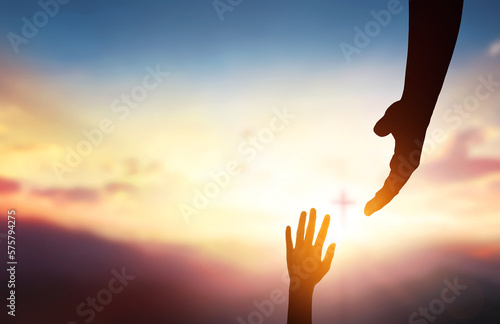 фотографія religious concept,God's helping hand and cross on sunset background