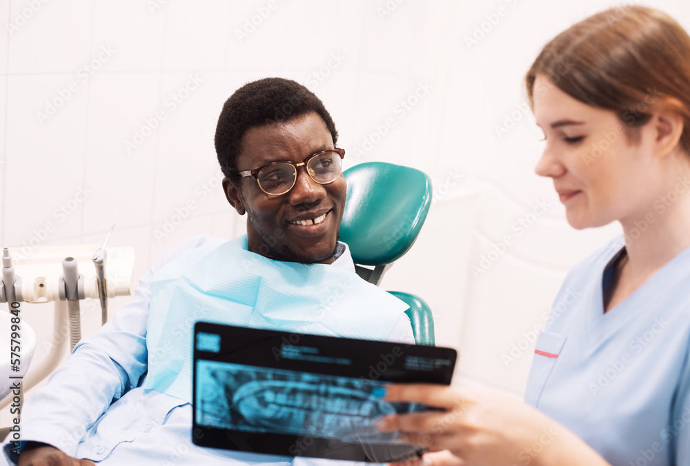 Young female dentist showing dental treatment result demonstrating teeth xray shot. Young female dentist showing dental treatment result demonstrating teeth xray shot.