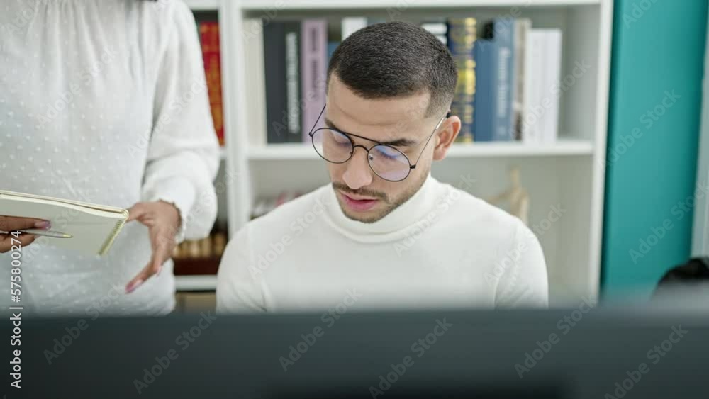 Man and woman student and teacher using computer studying at university classroom Man and woman student and teacher using computer studying at university classroom