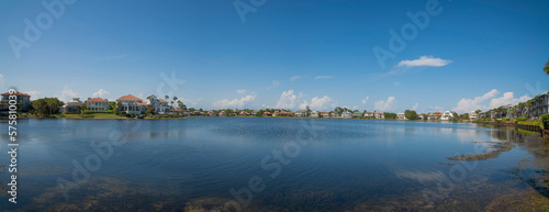 Fototapeta Naklejka Na Ścianę i Meble -  Clean reflective Four Prong Lake waterfront at Destin, Florida. Panorama of neighborhood with lakefront views and clear sky background.