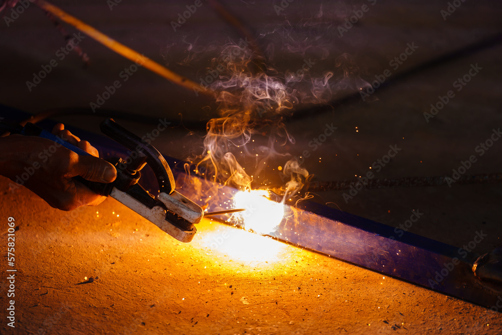 welder working with welding on metal with sparking light