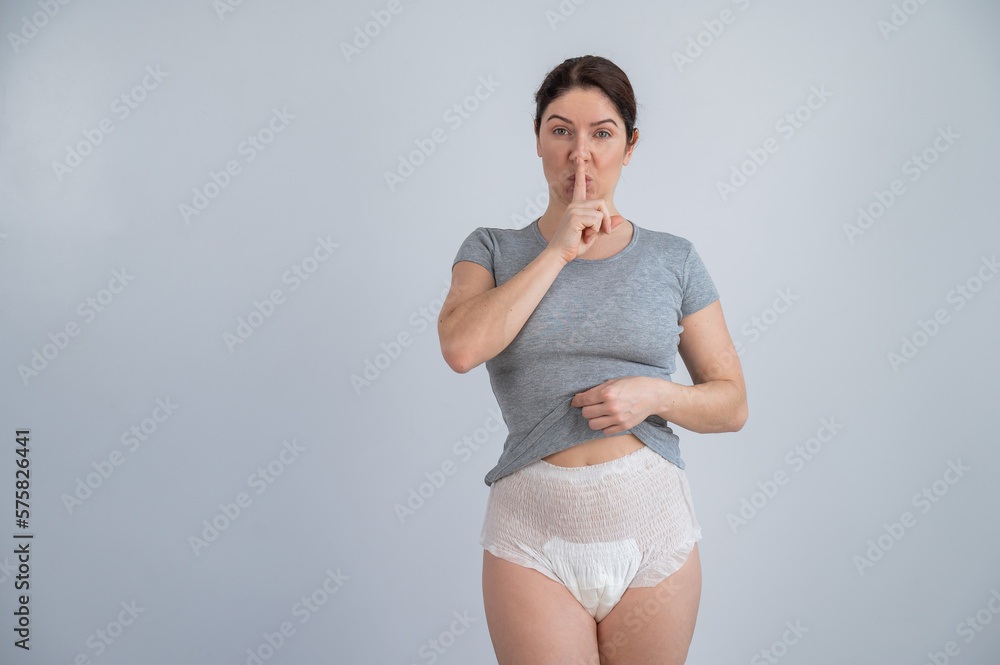 The woman is wearing adult diapers. Urinary incontinence problem. Finger on  lips - silent gesture. Stock Photo | Adobe Stock