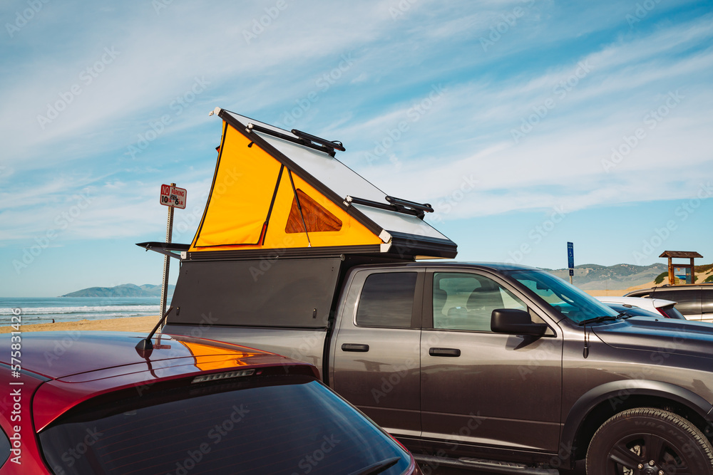 Car roof tent for camping. Car on parking lot close to the beach with ...