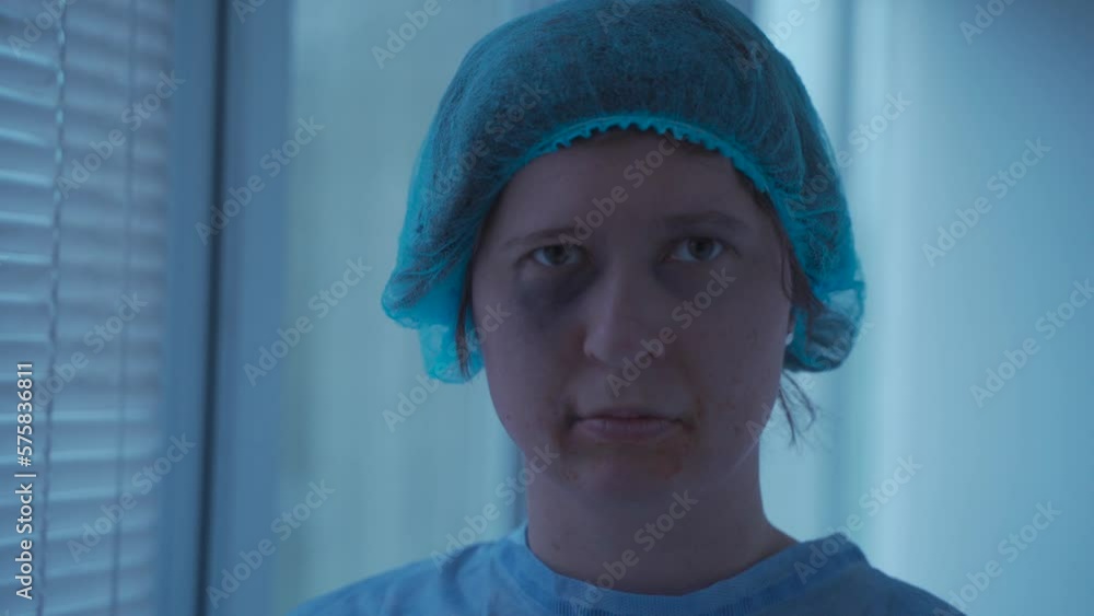 Hospital portrait of a woman with facial injuries experiencing pain and fear after a car accident in hospital attire. Victim of violence with facial injuries and dental at emergency room Hospital portrait of a woman with facial injuries experiencing pain and fear after a car accident in hospital attire. Victim of violence with facial injuries and dental at emergency room
