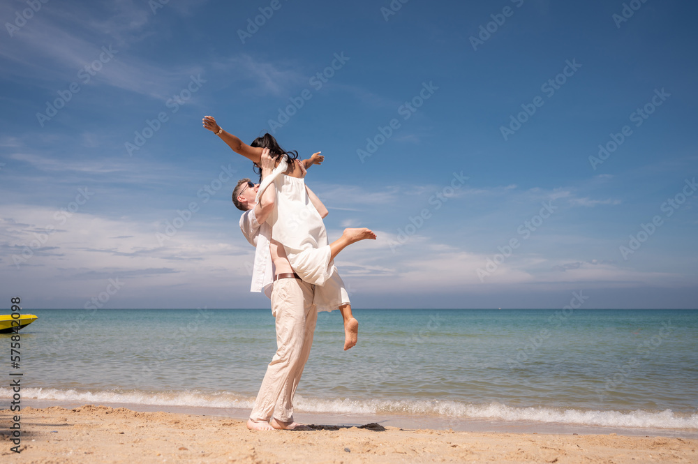 happy couple jumping on the beach romantic moments in honeymoon trip. happy couple jumping on the beach romantic moments in honeymoon trip.