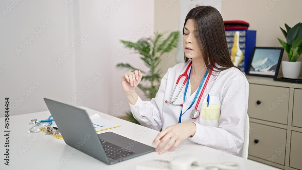 Young beautiful hispanic woman doctor using laptop working at clinic