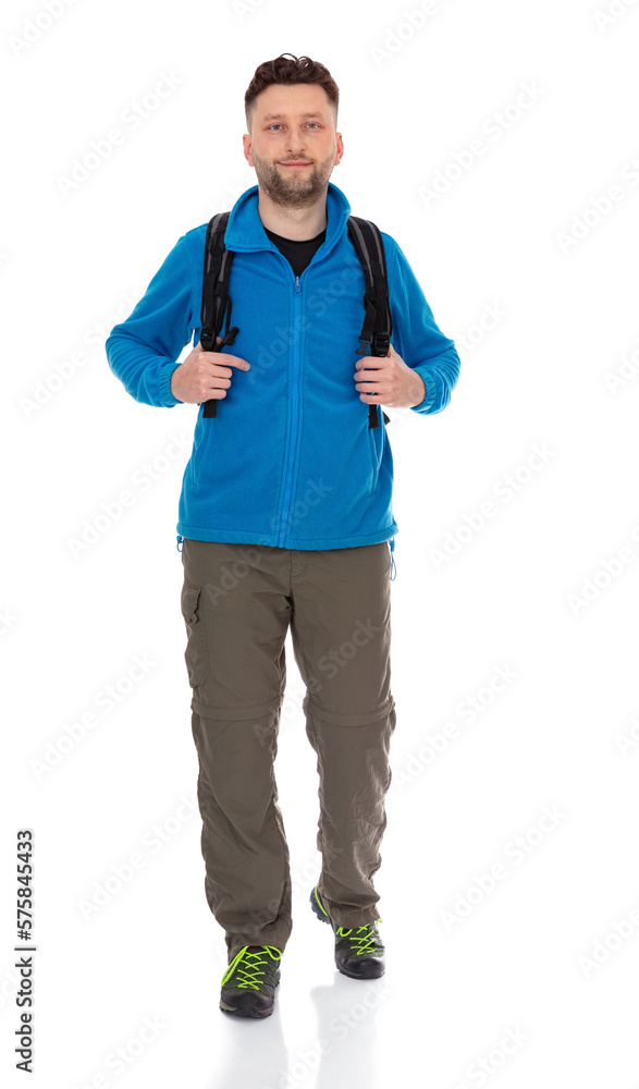 Full-length portrait of trekker with a backpack isolated on white background. Thirty years old man in blue jacket posing in studio. Full-length portrait of trekker with a backpack isolated on white background. Thirty years old man in blue jacket posing in studio.