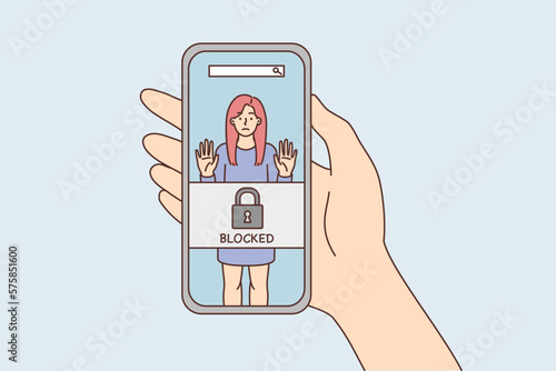 Phone in hand with photo of woman and inscription blocked due to unacceptable behavior